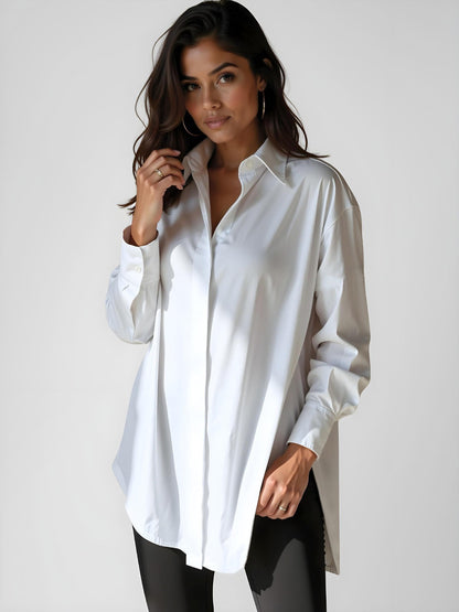 Woman wearing a white buttoned long shirt dress, standing and facing forward to show the fit and style.
